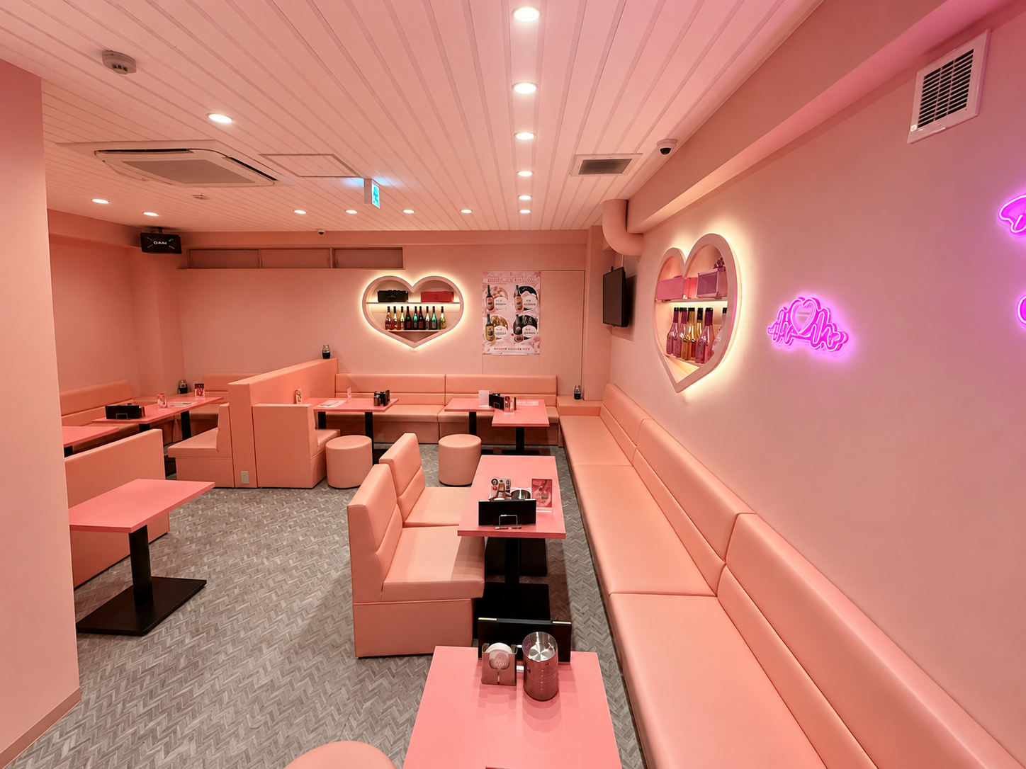 PINK MONSTER 梅田店 店内(ピンクの壁とハート型の間接照明、ソファ席とネオン)